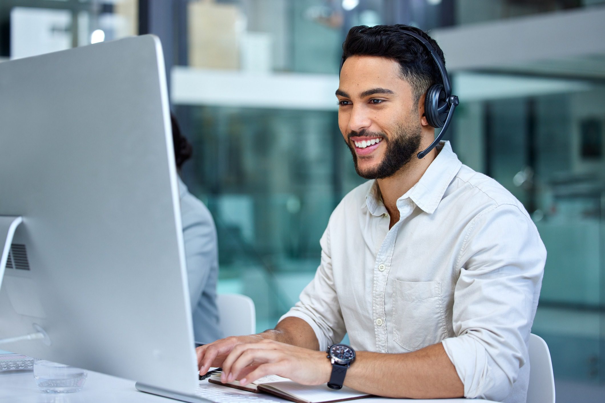 Shot of a businessman using a computer while working in a call center Shot of a businessman using a computer while working in a call center