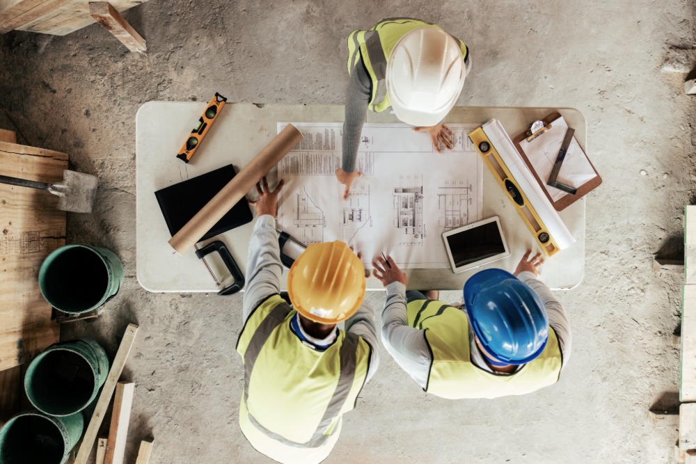 Top view, construction workers or blueprint planning in house, home or office building in real estate to help illiustrate construction and real estate IT services.<br />
