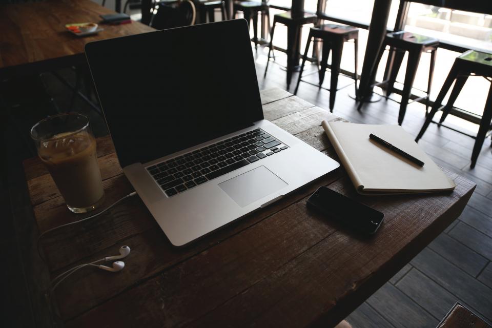 Laptop and phone on a cafe table connected to secure, separated guest Wi-Fi