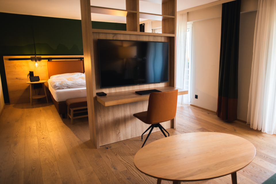 Modern hotel room with smart TV and workspace, part of a connected hospitality environment